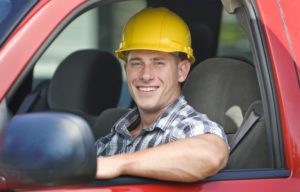 Construction Worker in hard hat and truck on the job site.